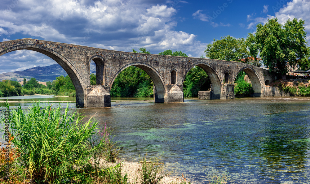 The historic stone bridge of Arta at the banks of Arachthos river in Epirus Greece on a summer day (west view)