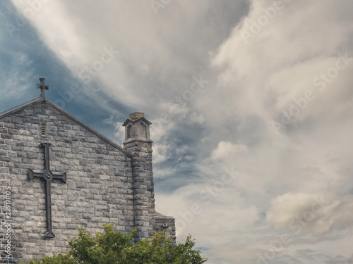 Wall of Galway Cathedral with crosses on a bright dramatic sky background. Ireland.