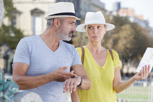 mature woman holding map man stressing the time restrictions