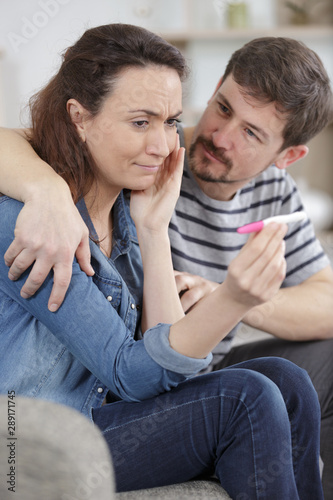 sad woman shows negative pregnancy test