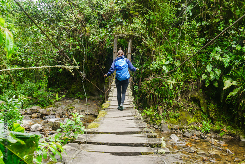 View on girl on bridge over river in cocora valley, Colombia