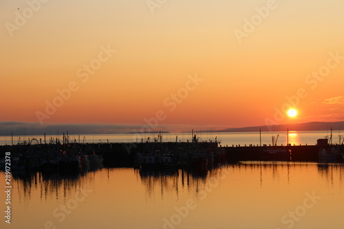 Sunset over fisher boats on a lake © Gabi