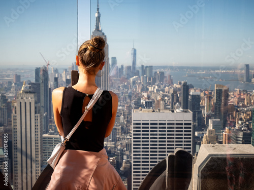 Cute girl taking photos of the Skyline of Manhattan from the Rockefeller Top of the Rock Center