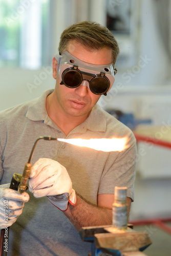 man wearing protective eyewear using gas torch