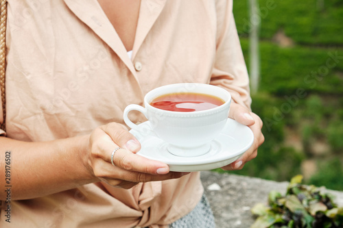 Woman with Drink Cup on Plantation Background