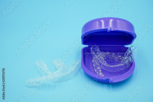 clear plastic retainer teeth in the box set isolated on blue sky background. it's an equipment for orthodontist give the patient to orthodontic surgery in dental clinic or hospital