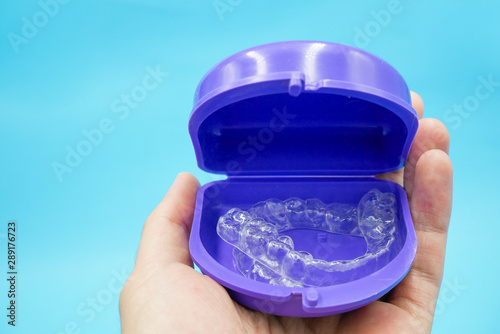 clear plastic retainer teeth in the box set isolated on blue sky background. it's an equipment for orthodontist give the patient to orthodontic surgery in dental clinic or hospital