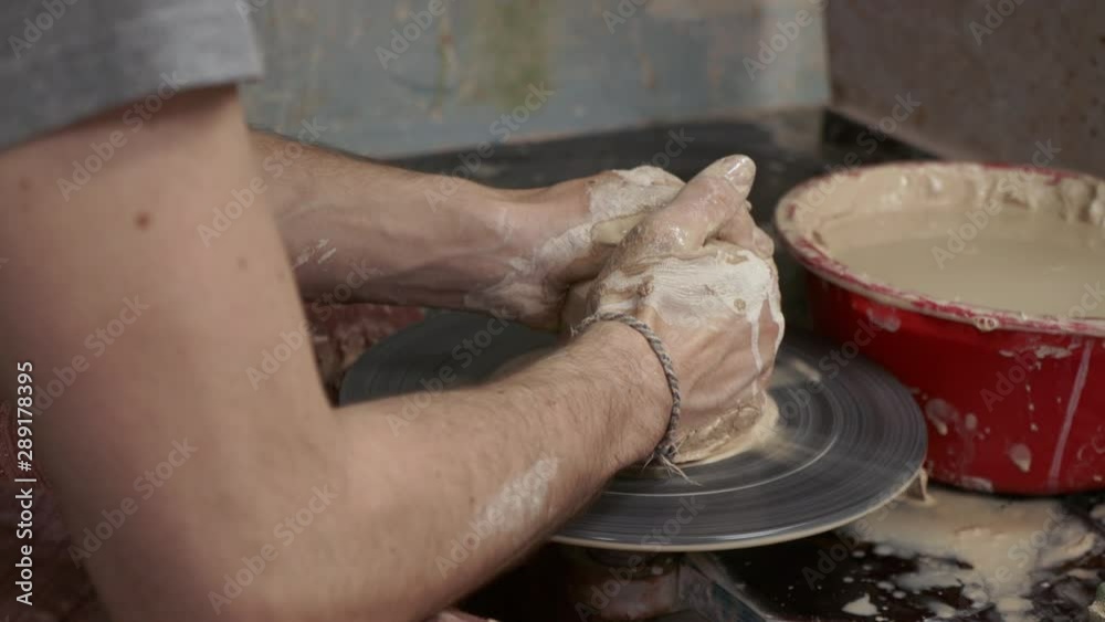 The potter makes a jug of clay. Ceramist. A man makes a vase on a potter's wheel. Hands of the master turn a piece of clay into a jug. Handwork. Pottery. Sculptor's wet hands close up. Clay dishes The potter makes a jug of clay. Ceramist. A man makes a vase on a potter's wheel. Hands of the master turn a piece of clay into a jug. Handwork. Pottery. Sculptor's wet hands close up. Clay dishes