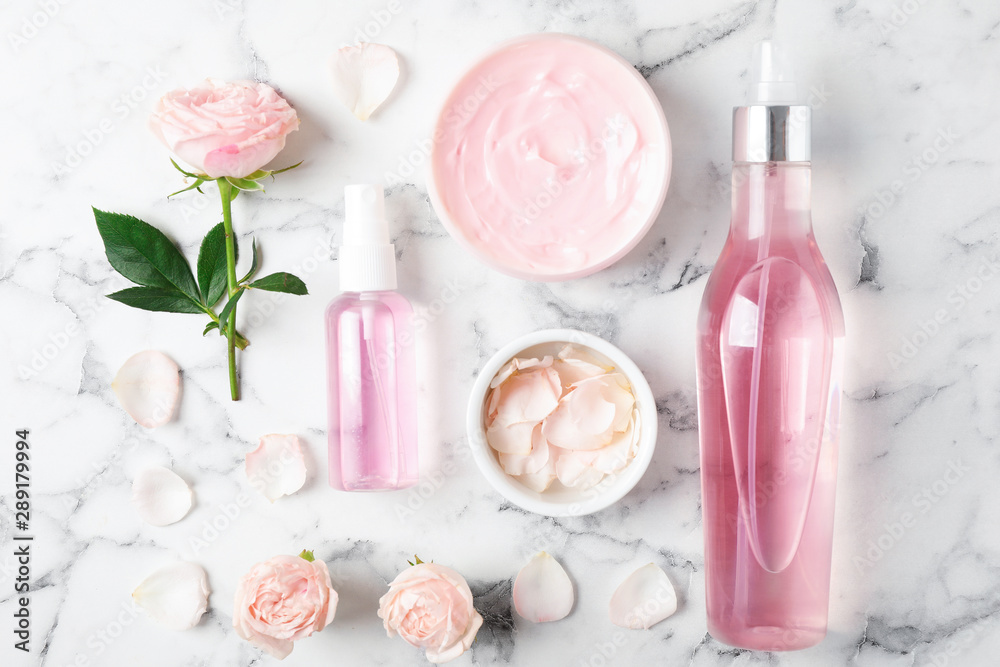 Flat lay composition with rose essential oil on marble table Flat lay composition with rose essential oil on marble table