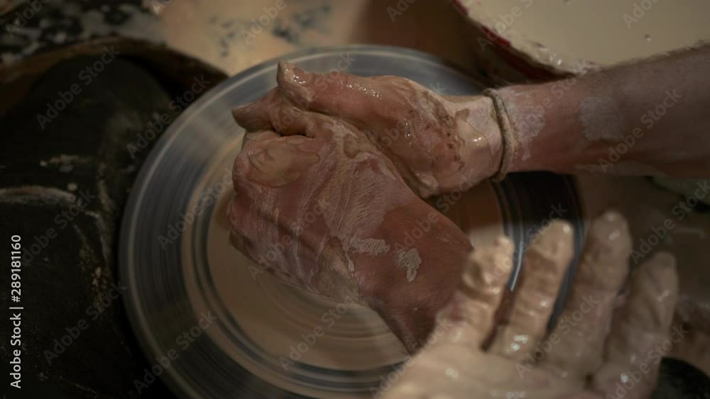A potter teaches a woman to make clay dishes. A man takes a woman's hands. Ceramist makes a jug of clay on a potter's wheel. Family business. Help. The master teaches the student. Pottery workshop. A potter teaches a woman to make clay dishes. A man takes a woman's hands. Ceramist makes a jug of clay on a potter's wheel. Family business. Help. The master teaches the student. Pottery workshop.
