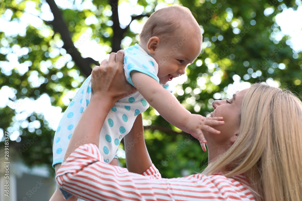 Obraz premium Nanny with cute baby outdoors on sunny day