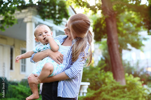 Foto Teen nanny with cute baby outdoors on sunny day