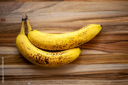 Two ripe bananas on rustic wooden background