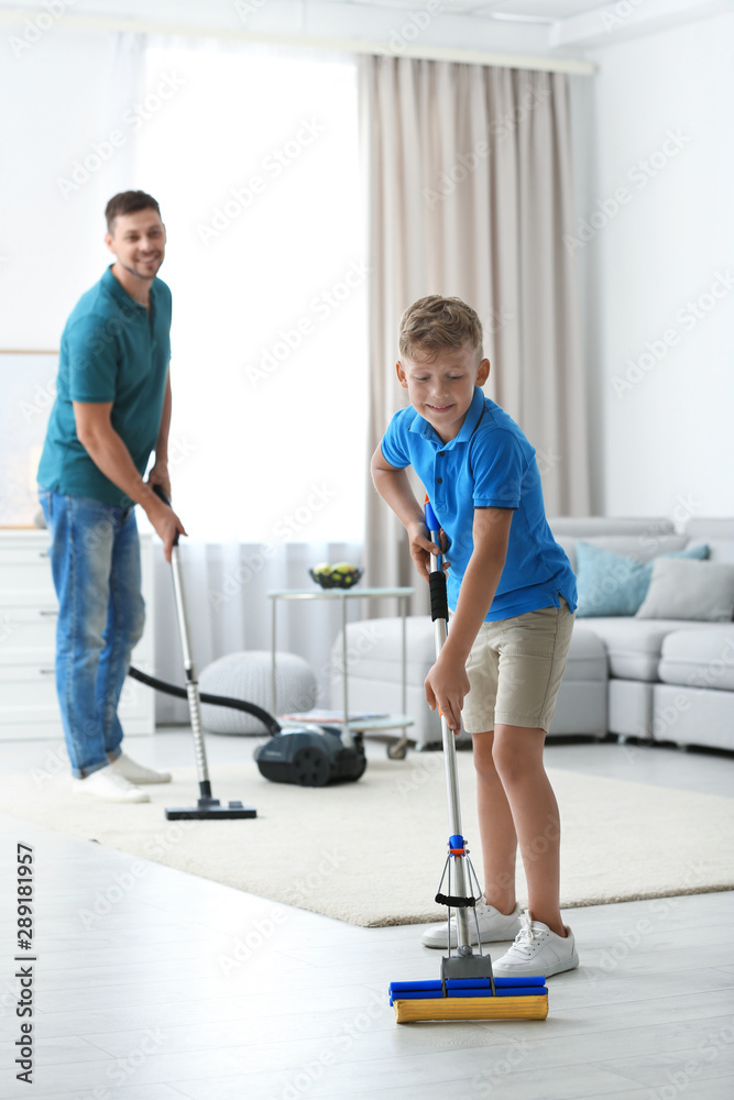 Dad and son cleaning living room together Dad and son cleaning living room together