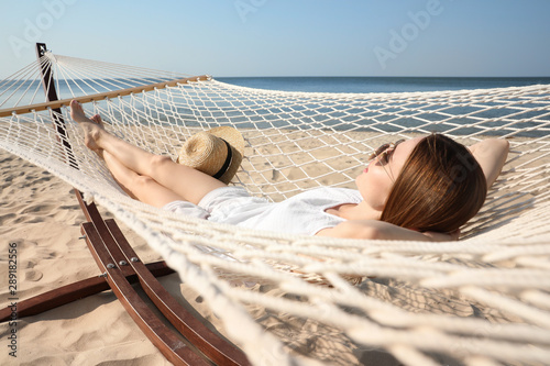 Young woman relaxing in hammock on beach © New Africa