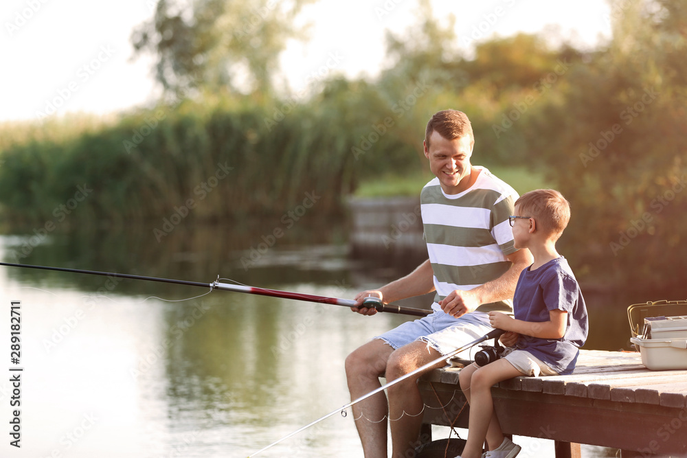 Dad and son fishing together on sunny day Dad and son fishing together on sunny day