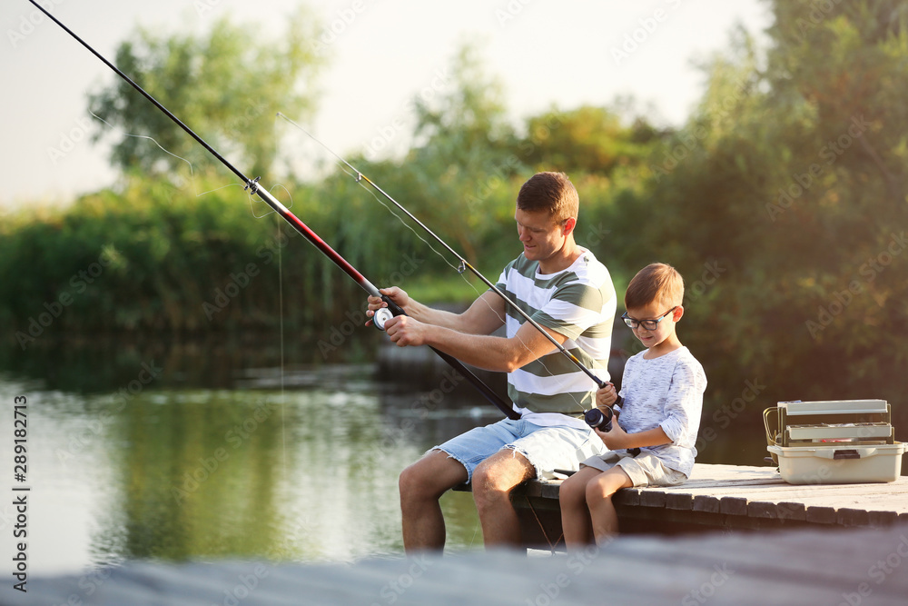 Dad and son fishing together on sunny day Dad and son fishing together on sunny day