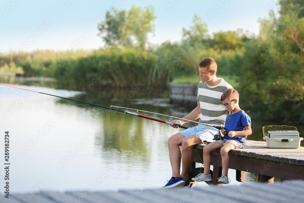 Dad and son fishing together on sunny day Dad and son fishing together on sunny day