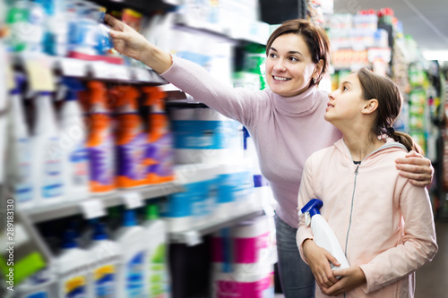 Adult glad woman with daughter choosing cleaners