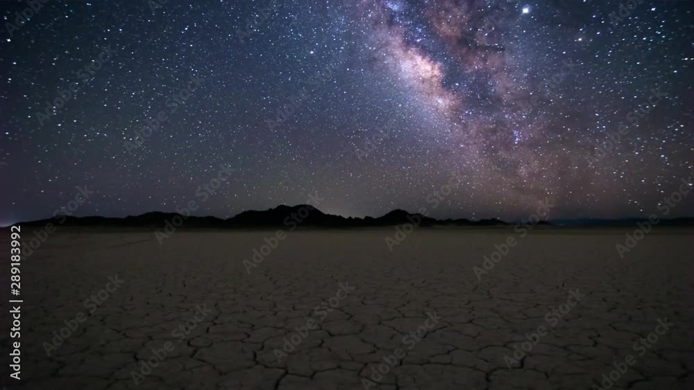 Timelapse of the colorful milky way above a dried river bed in Mexico displaying endless stars and even some planes at the night sky