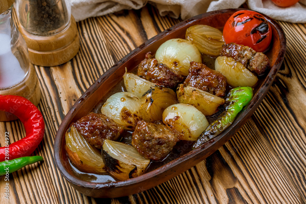 Beef kebab with onions in Turkish on the board Beef kebab with onions in Turkish on the board
