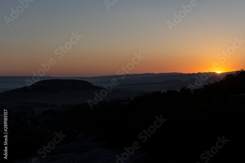 Dawn in the mountains. Mountain landscape. The sun rises from the horizon. Beautiful background early hours in the highlands. Bright rays shine from afar.