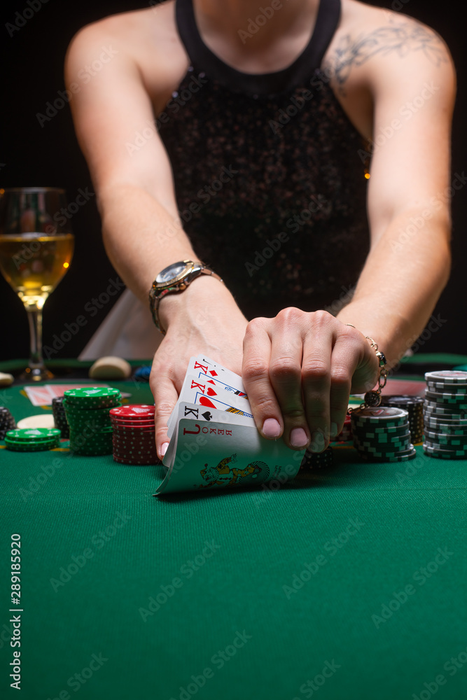 Girl playing poker and looking at cards. Vertical frame with space. Casino Concept, Player, Winner. Gaming Business Girl playing poker and looking at cards. Vertical frame with space. Casino Concept, Player, Winner. Gaming Business