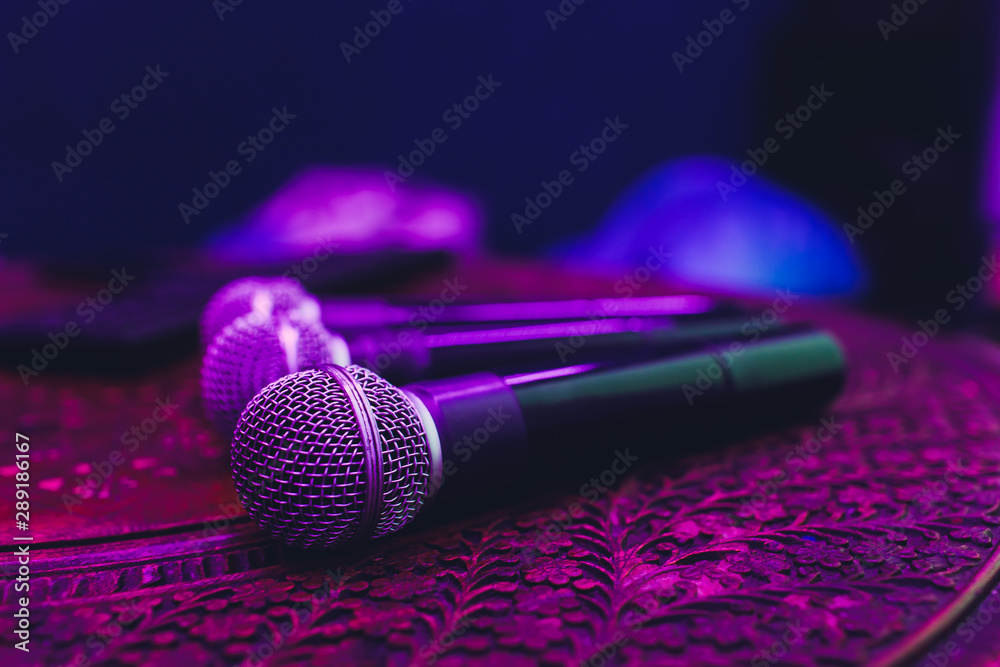 three Microphones in group on red table with copy space. - obrazy, fototapety, plakaty 