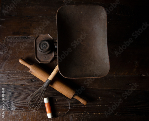 Antique baking equipment arranged on a dark wooden table