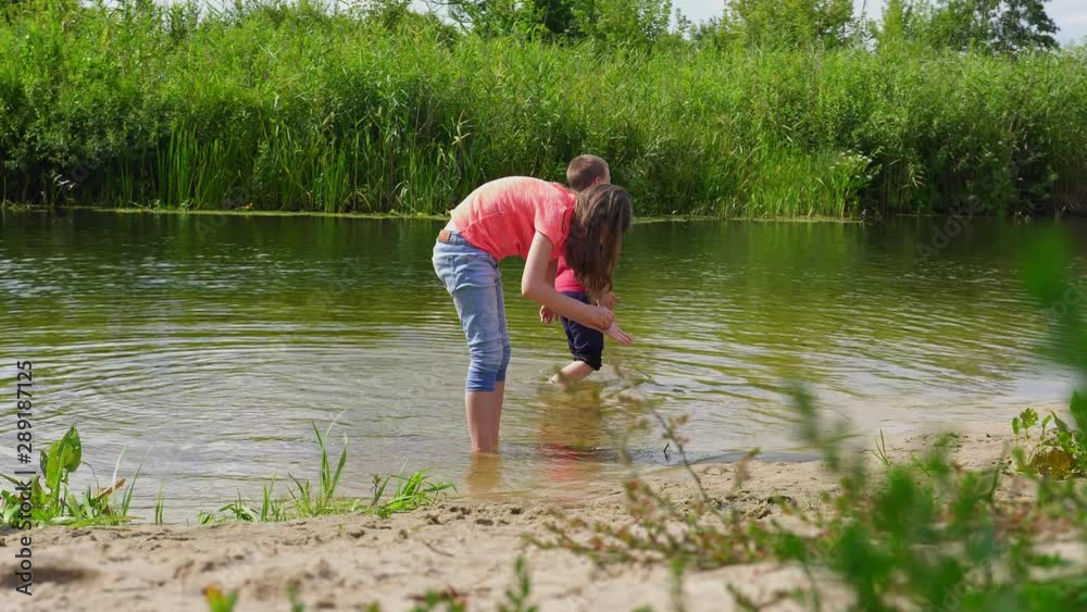 children looking for snails in the shallow river children looking for snails in the shallow river