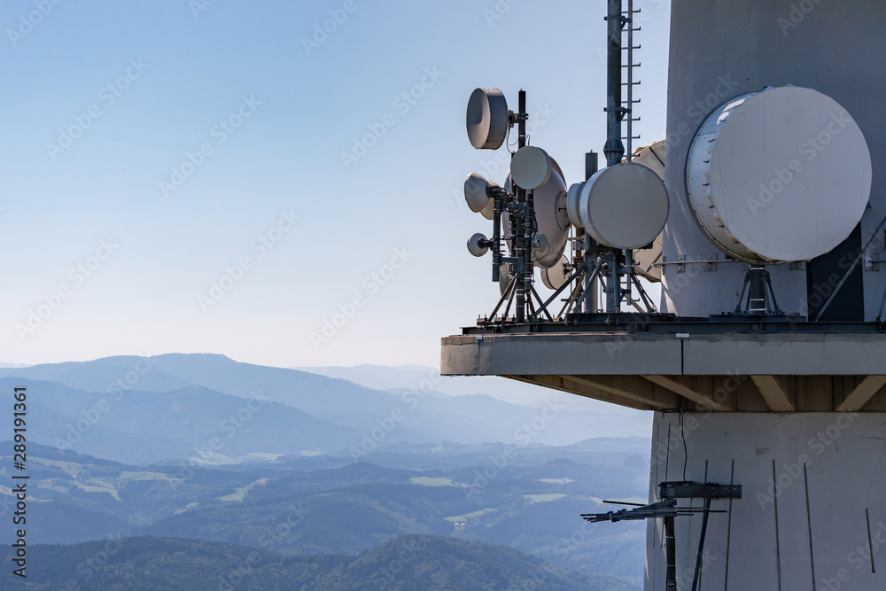Directional radio antennas on a radio tower over the mountain peaks of ...