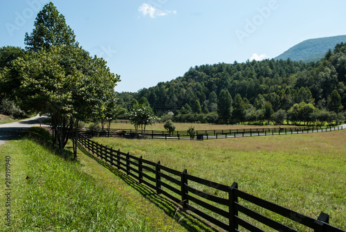 A shot of the stunning Georgia landscape. Fields  mountains and trees under a blue sky