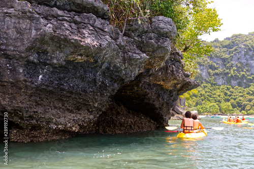 Group of tourist kayaking in the ocean sea explore near the island with lush green jungle trees and lime stone mountains in Ang Thong National Marine Park,Surat Thani, South of Thailand