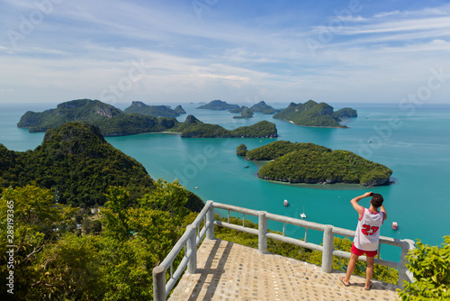 A tourist is taking a photo at viewpoint deck in Koh Wua Ta Lap, blue turquoise ocean and group of islands in Ang Thong National Marine Park in the Gulf of Thailand. Surat Thani, Thailand 
