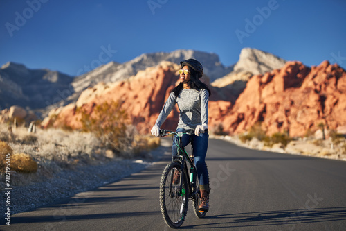 african american woman riding bicycle through red rock canyon park