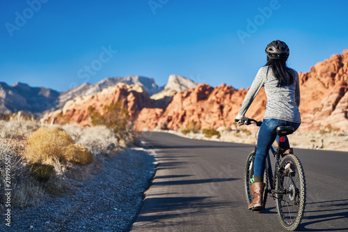 african american woman riding bicycle through red rock canyon park