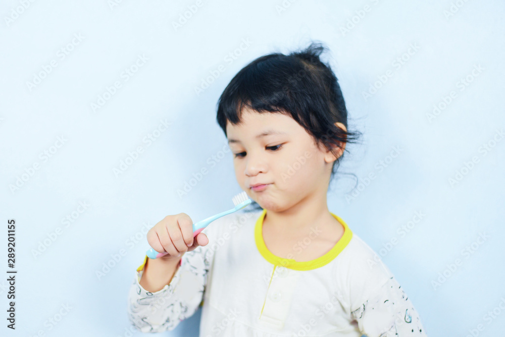 Asian little girl brushing teeth with toothbrush in hand dental hygiene - child don't brush teeth Asian little girl brushing teeth with toothbrush in hand dental hygiene - child don't brush teeth