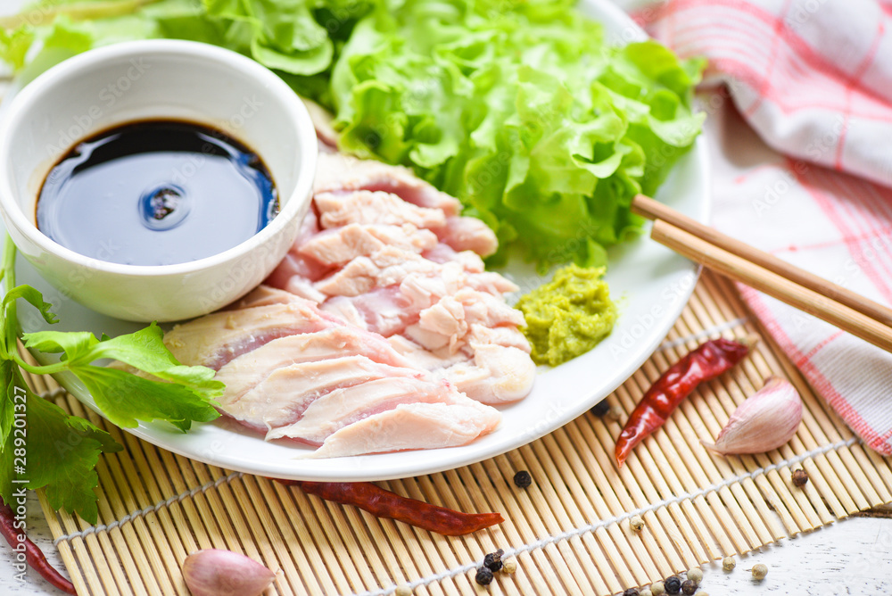Sashimi raw chicken on white plate with wasabi sauce and vegetable salad garlic chilli herbs and spices traditional japanese food - chicken slices meat fillet