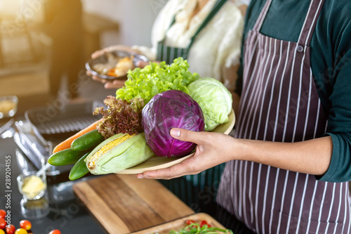 Teen showing shrimp and vegetables in the kitchen photo