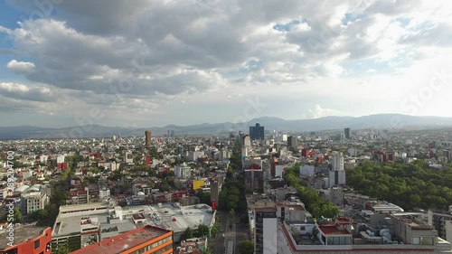 Panoramic view of Mexico City, CDMX, drone flying over Insurgentes avenue on a cloudy day with blue sky