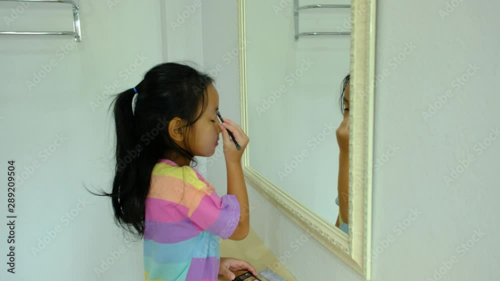 4K : Kid learning makeup concept., Asian kid girl enjoy blowing on a makeup. 4K : Kid learning makeup concept., Asian kid girl enjoy blowing on a makeup.