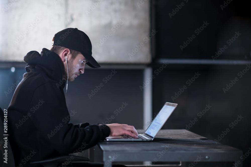 talented hacker using laptop computer while working in dark office talented hacker using laptop computer while working in dark office