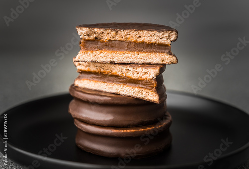 Alfajor with dulce de leche sweet pastry cake, a traditional Argentine dessert with chocolate and caramel