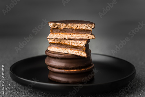 Alfajor with dulce de leche sweet pastry cake, a traditional Argentine dessert with chocolate and caramel