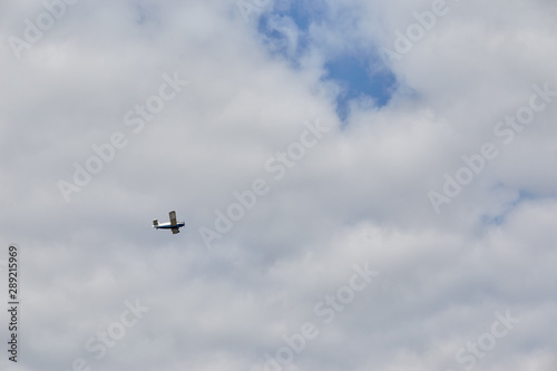 Small airplane flying in the sky with clouds