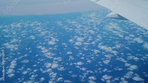 A shot of thousands of tny clouds taken from a plane during  the flight photo