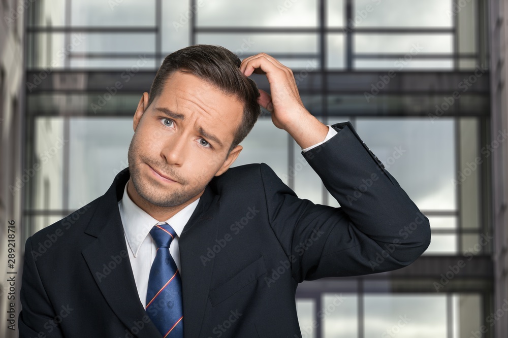 Young businessman scratching his head, hard decision Young businessman scratching his head, hard decision