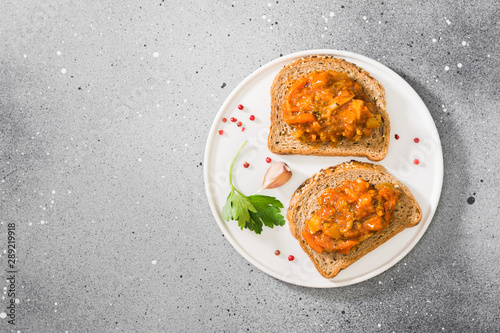 Fototapeta Naklejka Na Ścianę i Meble -  Bread with vegetable caviar on a white tray on a light gray table