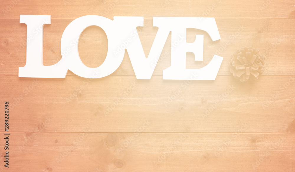 White love text and pine cone decoration on wooden background White love text and pine cone decoration on wooden background