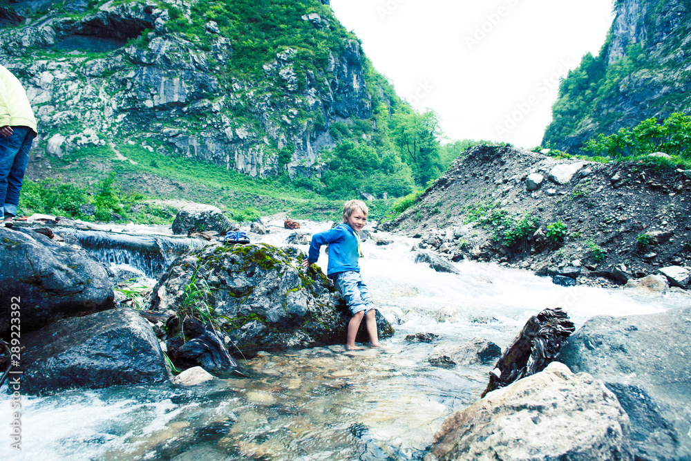 little cute boy playing in mountain river, lifestyle people on summer vacation concept little cute boy playing in mountain river, lifestyle people on summer vacation concept